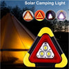 A red and yellow triangular solar camping light with three LED lights and a flashlight shown next to a tent.