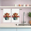 A set of two Highland cow kitchen towels featuring floral designs displayed on a kitchen shelf.