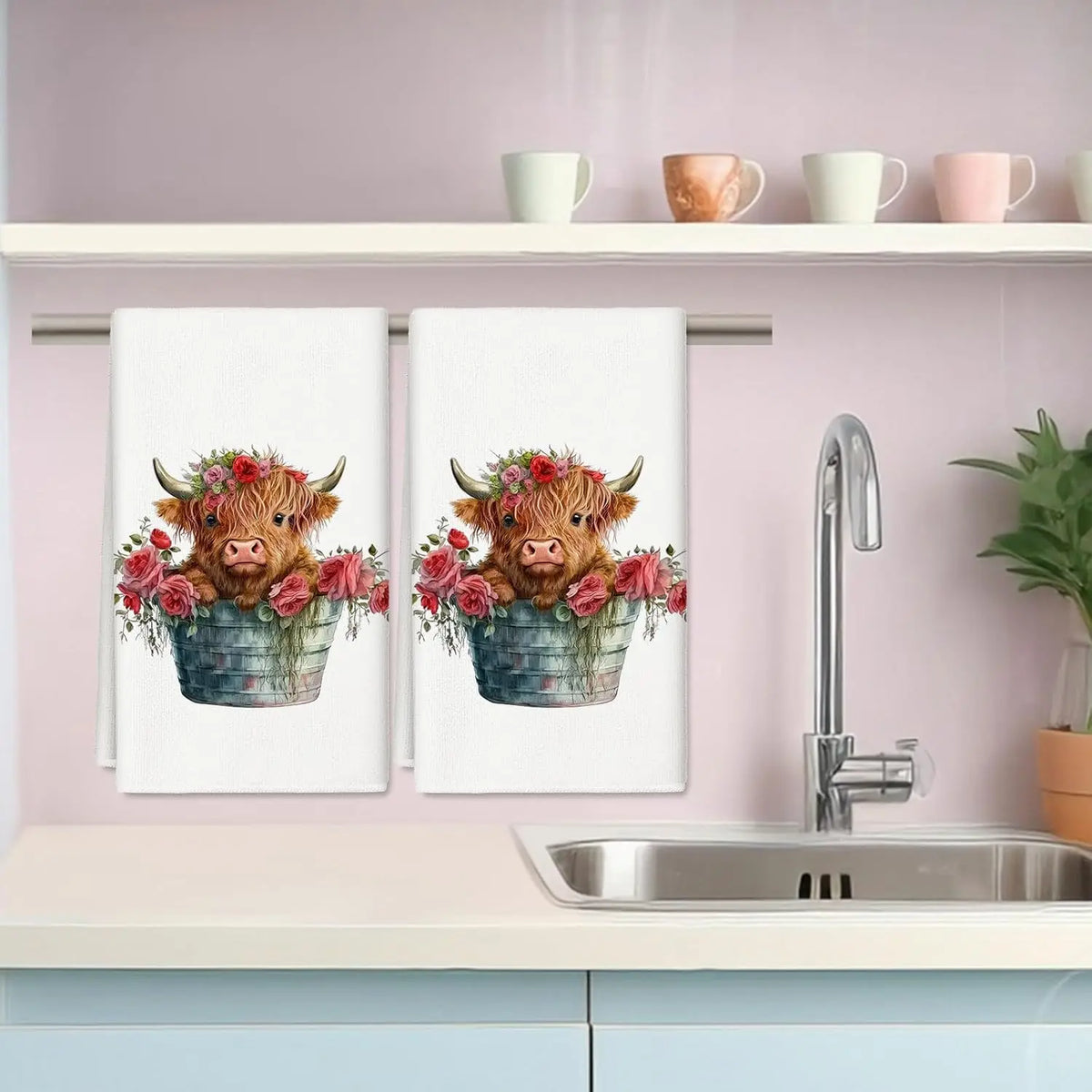 A set of two Highland cow kitchen towels featuring floral designs displayed on a kitchen shelf.