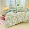 Hellgrüne Blumen-Duvetcover mit weißem Hintergrund auf einem Bett in einem hellen Raum.