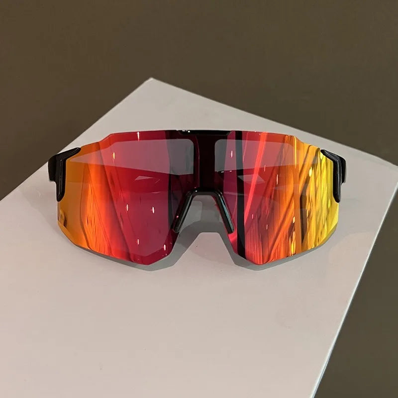 A pair of orange and red tinted sunglasses resting on a white surface.