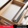 A roll of silver self-adhesive grease proof kitchen sticker is displayed inside a wooden cabinet drawer.