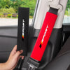 A red and black soft car seat belt cushion is shown being placed into a car seat, highlighting its sport design.