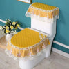 A white toilet seat covered with a yellow quilted fabric and lace trim, set for antibacterial use.