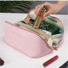 A pink leather travel makeup organizer bag is shown open, revealing various cosmetic bottles and makeup items.