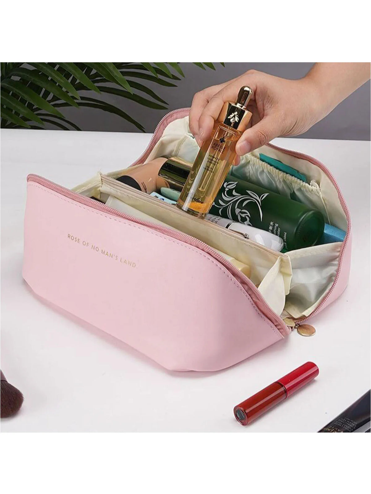 A pink leather travel makeup organizer bag is shown open, revealing various cosmetic bottles and makeup items.