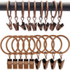 Un juego de anillos y clips metálicos de color cobre para cortinas, dispuestos en fila horizontal.