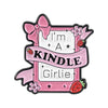 Pink enamel pin featuring a ribbon design with the text I'm a kindle girl and a strawberry.
