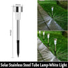 A vertical view of a solar stainless steel tube lamp with a white light, shown in a garden path context.
