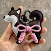 A black and white Shiba Inu PU leather bag charm featuring a braided pink bow.