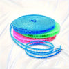 A stack of colorful windproof portable clotheslines in blue, cyan, green, and pink, with one line unwinding.