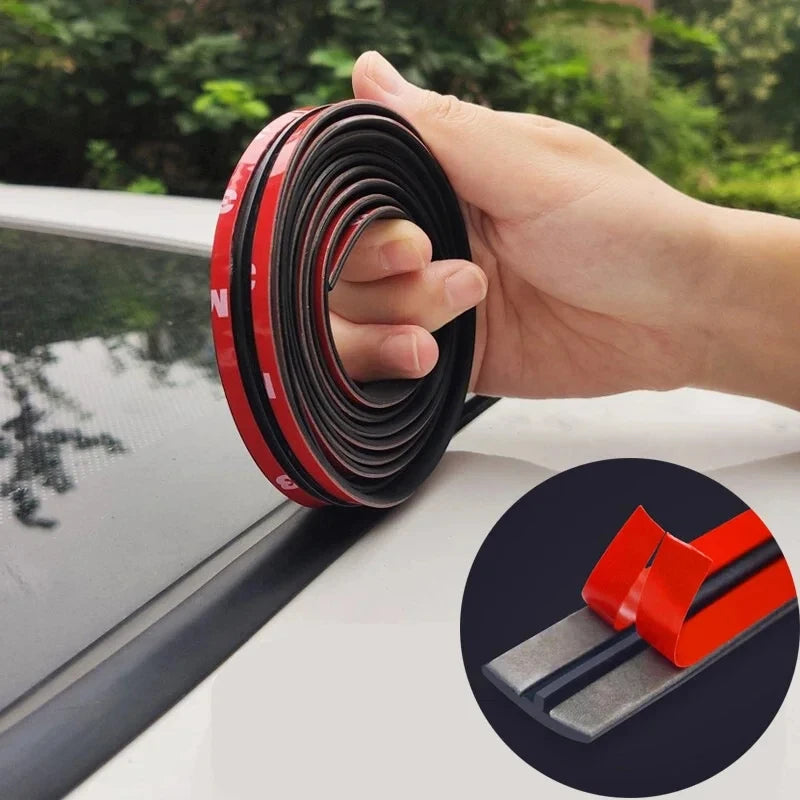 A hand is unwrapping a roll of red and black automotive rubber sealing strips for noise and weather protection.