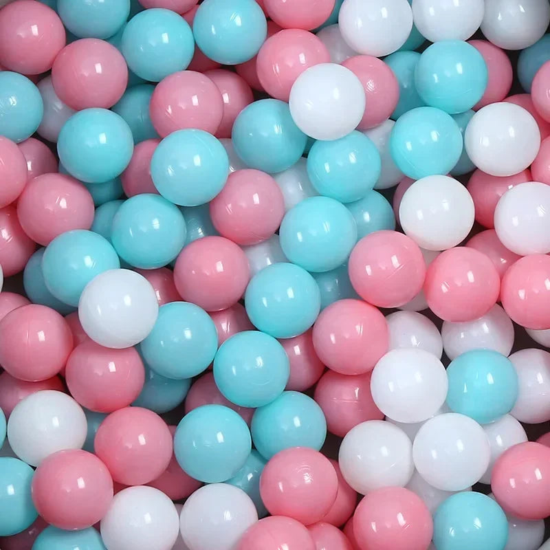 A large pile of colorful plastic ball pit balls in shades of pink, blue, and white.