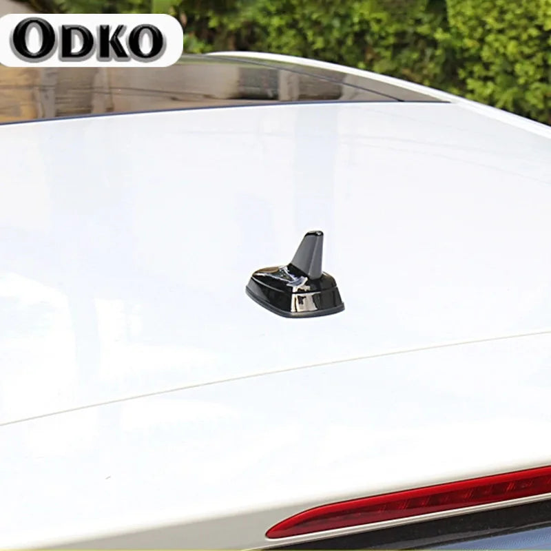 Sleek shark fin roof antenna for VW and Audi models mounted on a white car.