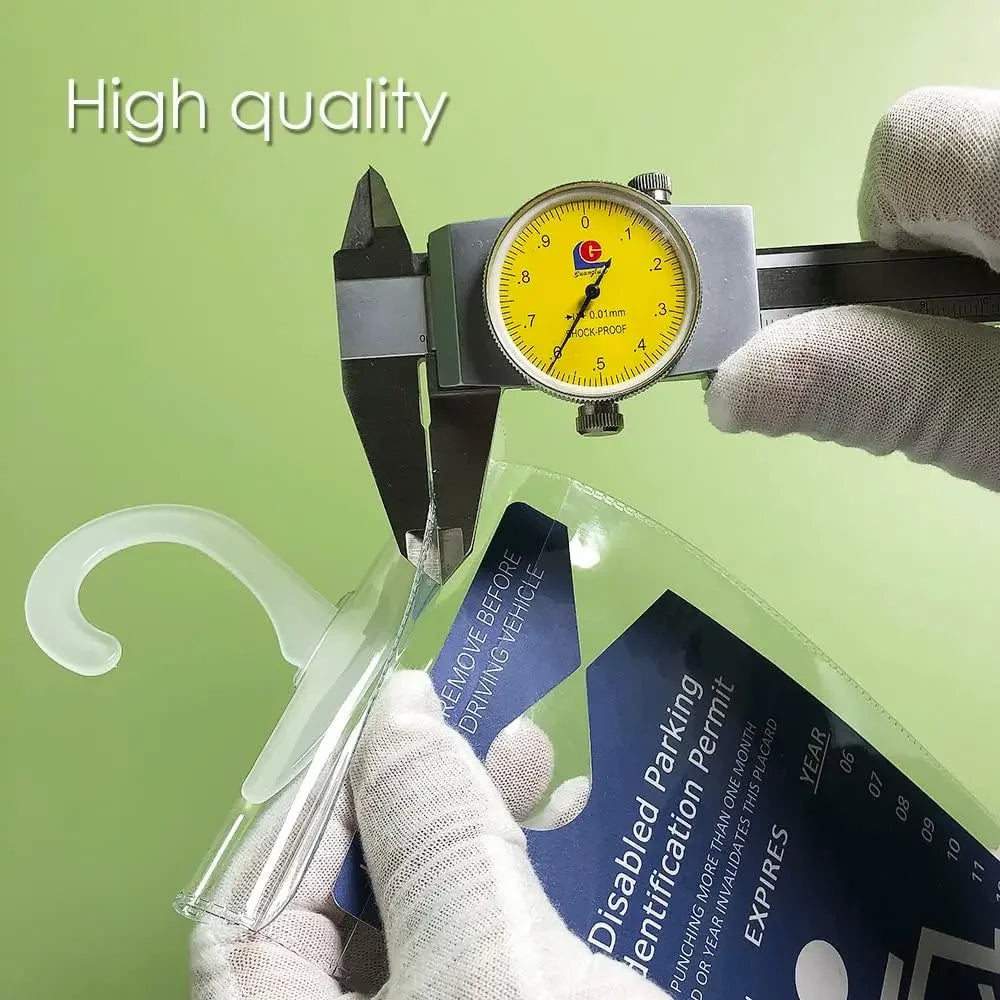 Una mano sostiene un soporte de matrícula transparente con cubierta protectora y un indicador amarillo.