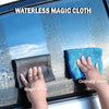 Hands are using a magic wipe to clean water spots off a glass surface.