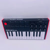 Black AKAI MPK Mini keyboard controller with 25 keys, drum pads, and knobs shown from the front.