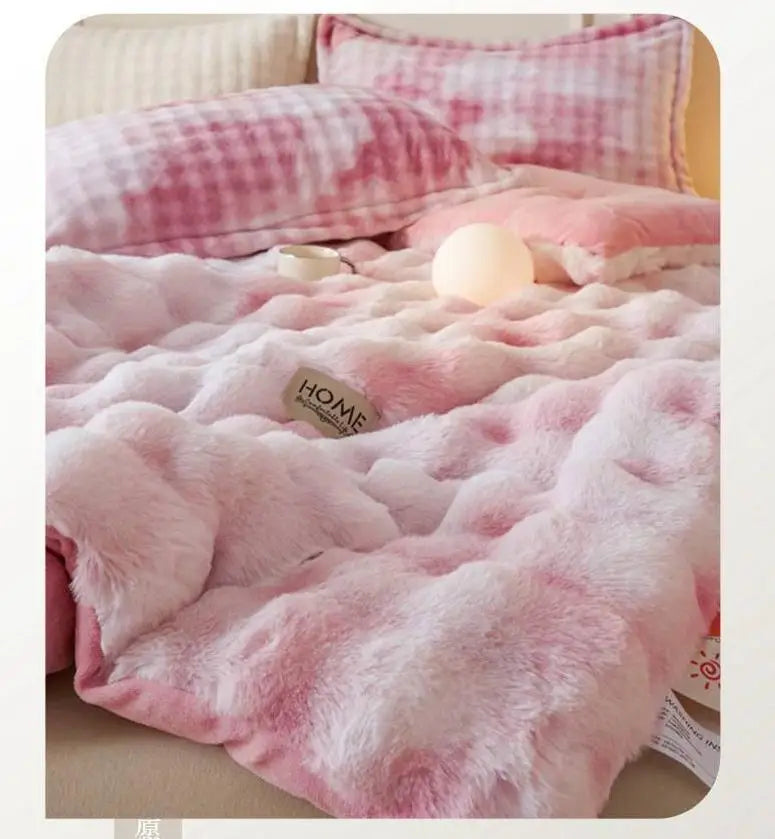 A pink and white checkered plush winter comforter or quilt with a fluffy texture.