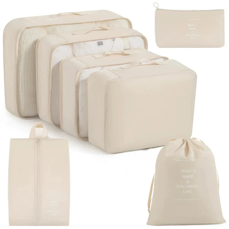 A set of beige travel packing cubes and storage organizer bags shown in various sizes.