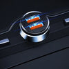 A close-up view of a silver USB-C car charger with two orange ports, illuminated by blue light on a black surface.