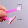 A hand holds a pink applicator pen with three and nine drill pens attached, showing the different sizes of the tips.