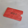 A red RFID protection card holder with a cutout, placed on a light gray surface.