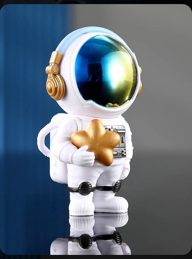 A white resin figurine of an astronaut with a reflective blue helmet and gold accents, displayed against a dark blue backgrou