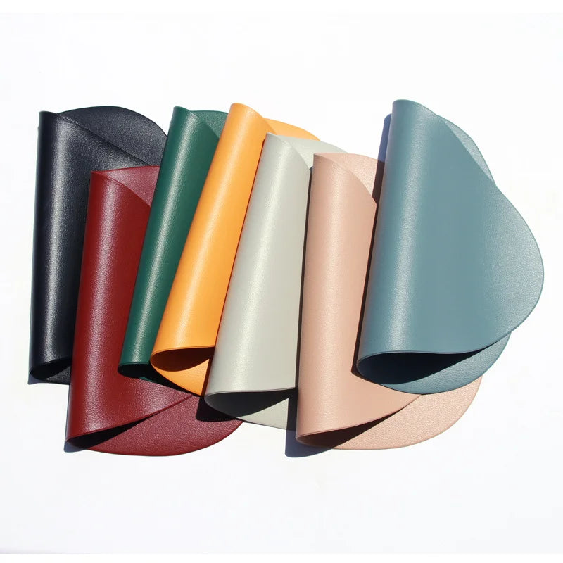 A collection of rolled, reversible non-slip placemats in various muted earth tones and greens.