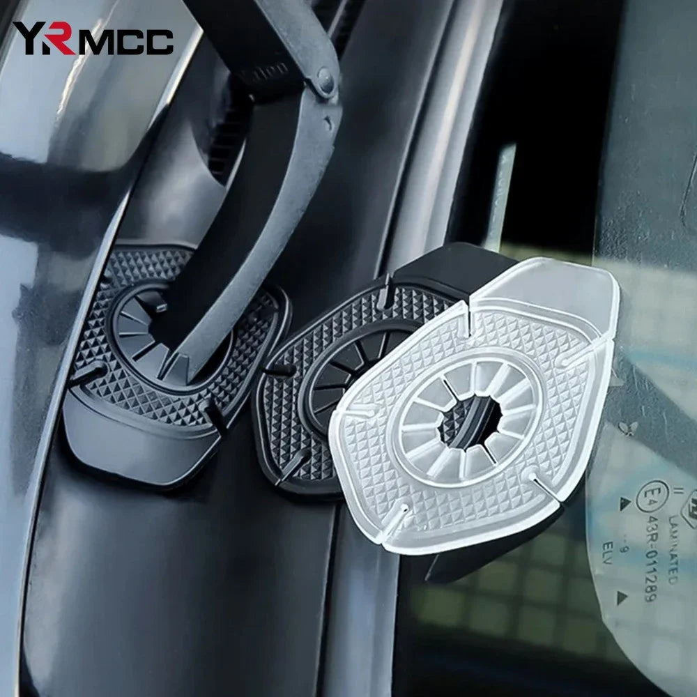 Two clear plastic protective covers for car windshield wiper holes are shown on a vehicle surface.