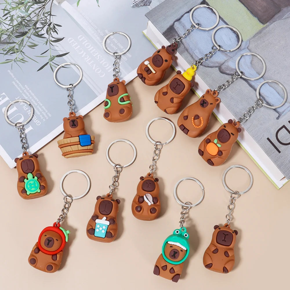A collection of adorable capybara keychain charms in various earthy tones and colors.