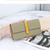 A beige women's cowhide leather bifold wallet with a yellow accent is held open on a light wooden surface.
