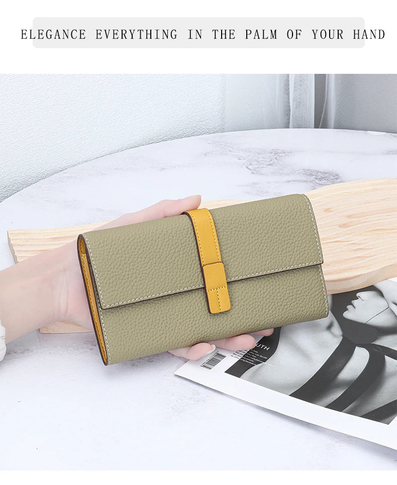 A beige women's cowhide leather bifold wallet with a yellow accent is held open on a light wooden surface.