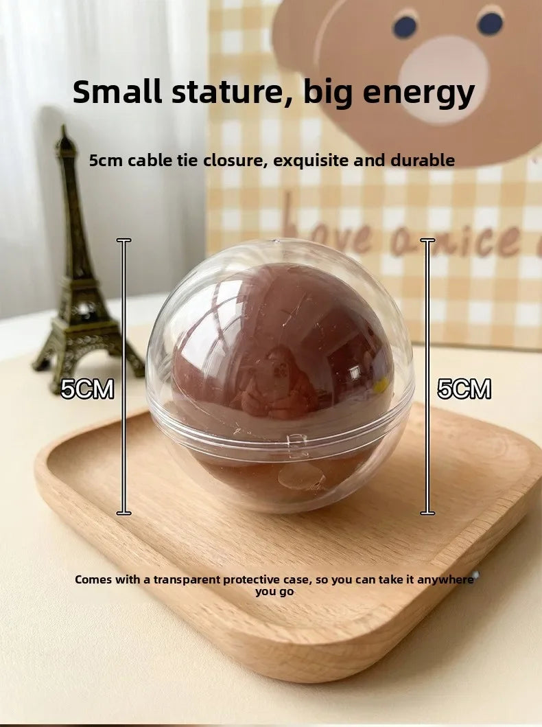A clear silicone stress ball with a pinkish-brown color is shown resting on a wooden tray.