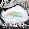 A close-up of a white motorcycle helmet featuring colorful wildstyle graffiti decals and black accents.