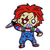 An enamel pin featuring Chucky the doll with red hair and a knife.