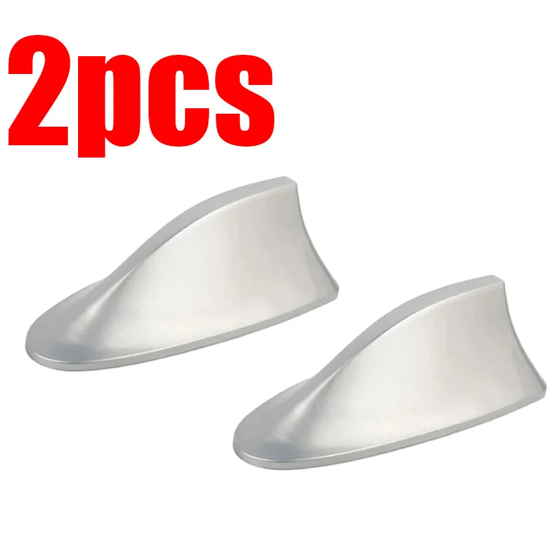 Two silver shark fin car antennas for FM/AM signal enhancement
