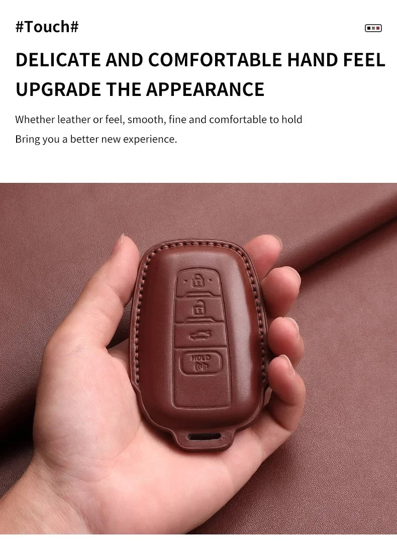 A hand holds a brown genuine leather car key case cover for Toyota models.