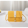 A yellow compact crossbody handbag with a white strap is displayed on a white surface.