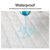 A glass of blue liquid is dripping onto a white quilted surface, demonstrating the waterproof property of the material.