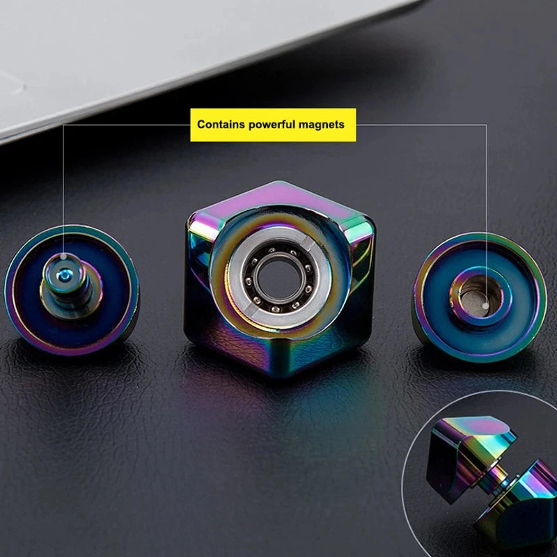 A close-up view of an alloy metal fidget cube spinner with colorful magnetic components on a dark surface.