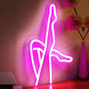 A bright pink neon silhouette of a stylized figure on a wall.
