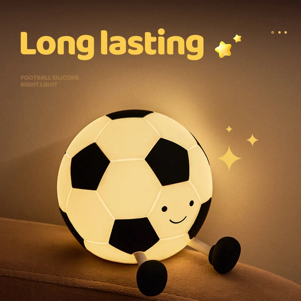 مصباح ليلي على شكل كرة قدم من السيليكون المتوهج يرقد على سطح.