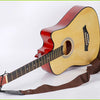 A vintage acoustic guitar with a sunburst finish and a brown strap is shown.
