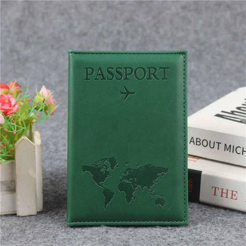 A dark green leather passport holder embossed with a world map design, resting on a gray surface.