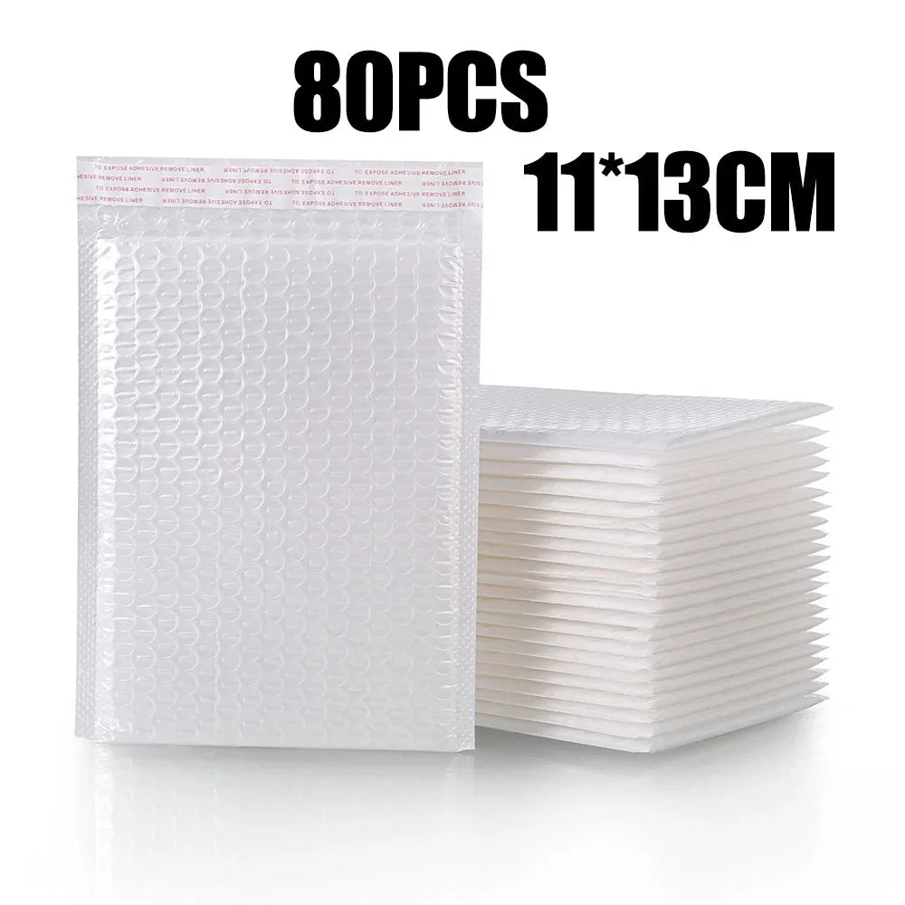 A stack of 80 white padded bubble mailers measuring 11x13cm.
