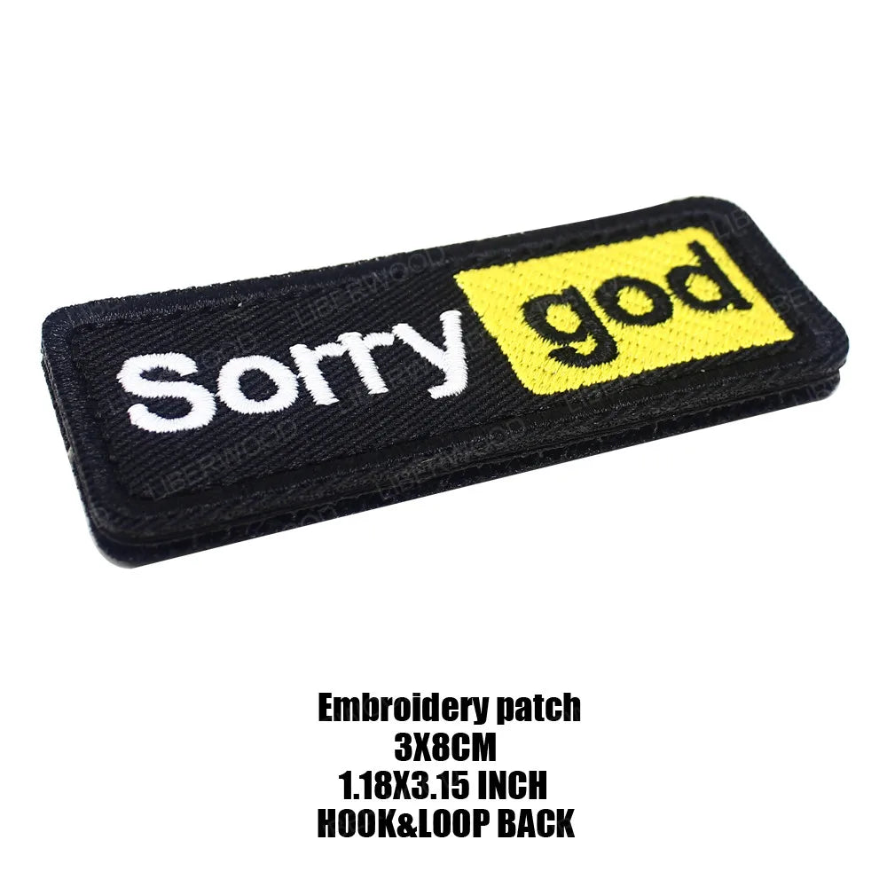 Black embroidered patch with yellow text saying Sorry god