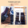Foldable pant rack showing a hanging garment and folded pants, demonstrating space-saving storage.