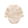 A cream-colored long-sleeved cotton romper for a baby girl with a button placket.