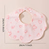 A pink, textured baby bib in a bandana style with a cutout and small pink hearts.