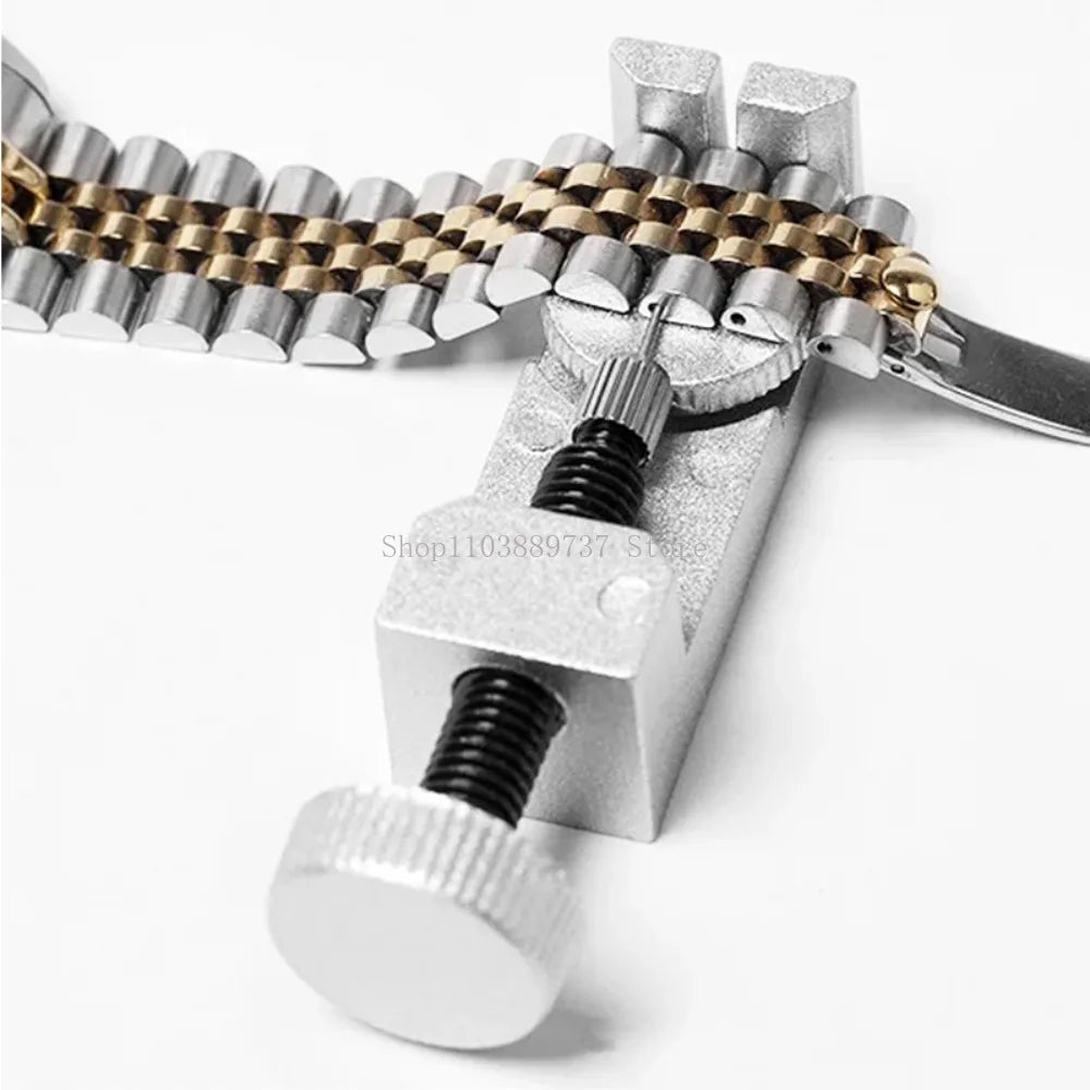 A silver watch band link remover and pin extractor kit with various tools and a gold-toned link.